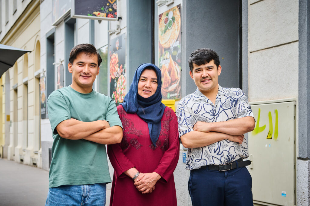 Hassan Mohammadi (ganz rechts) mit Mutter Hakima und Bruder Ammar vor Hassans Restaurant auf dem Mexikoplatz. 